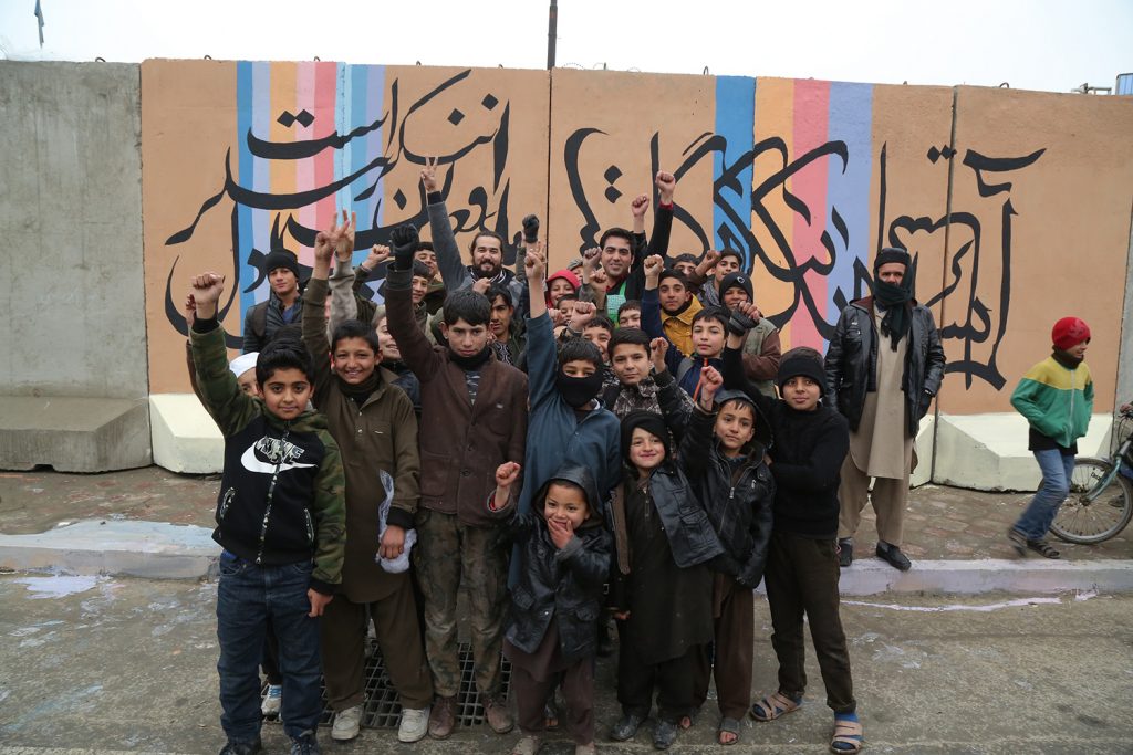 image of Afghan kids in front of a mural by ArtLords